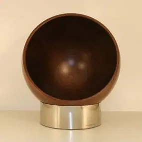 Dunkel gebeizte Kugel aus Holz auf einem Edelstahlsockel