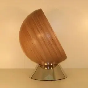 Kugel aus Holz auf einem Edelstahlsockel, schräg gestellt
