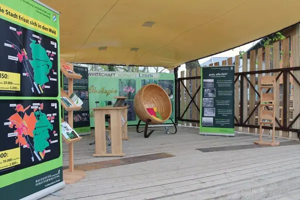 Sitzkugel aus Holz auf einem Ausstellungsstand der Landesgartenschau mit Infotafeln